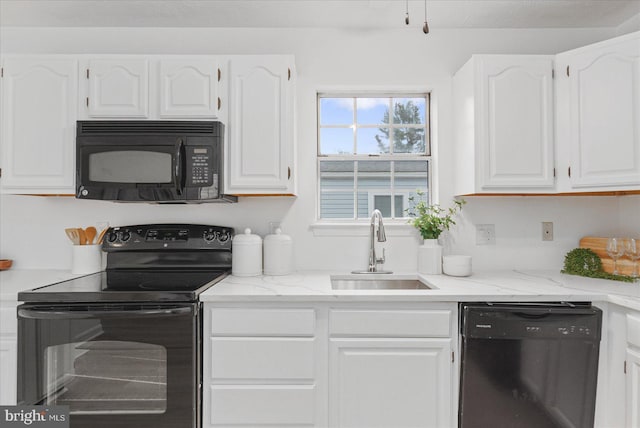 kitchen with black appliances, white cabinetry, and sink