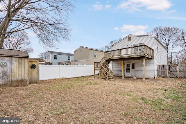 back of property with a lawn and a deck