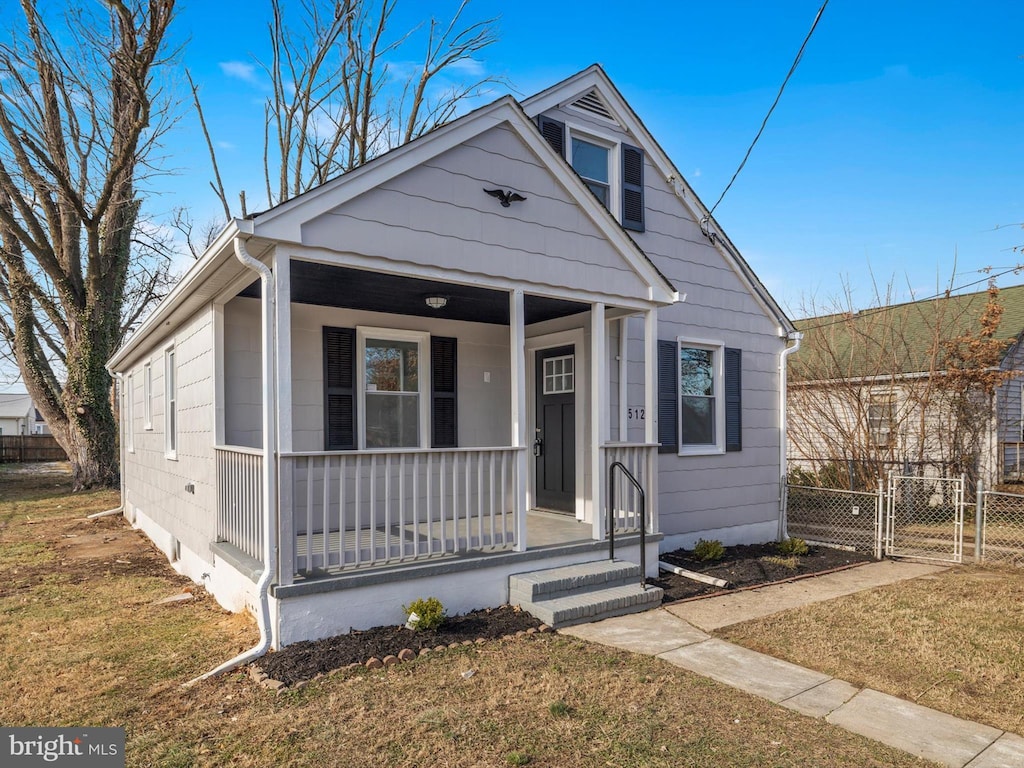 bungalow-style home featuring covered porch and a front yard