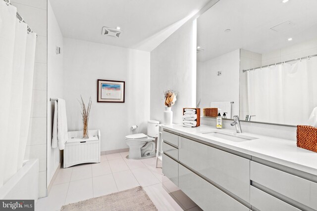 bathroom featuring tile patterned flooring, vanity, and toilet