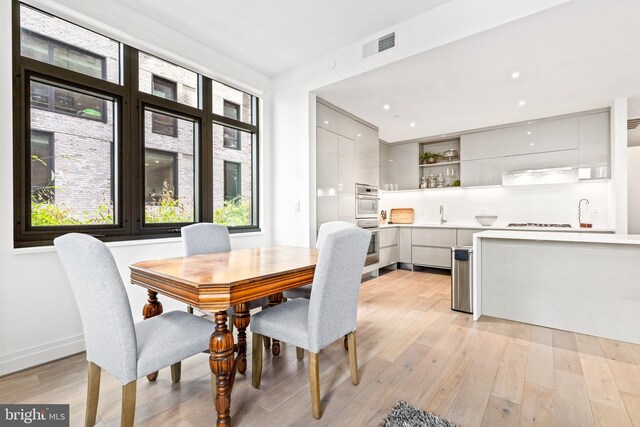 dining room with sink and light hardwood / wood-style floors