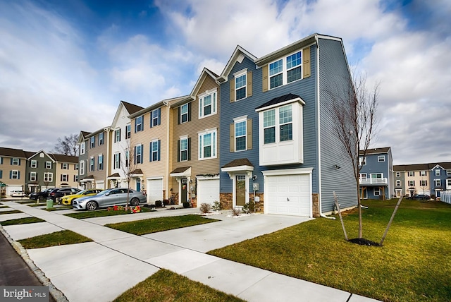 townhome / multi-family property with a front yard and a garage