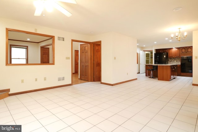 unfurnished living room featuring ceiling fan with notable chandelier, visible vents, and baseboards