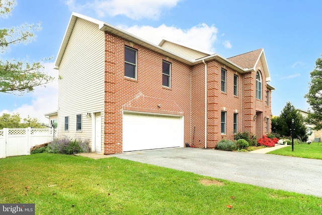 view of front of property with a front yard, fence, driveway, an attached garage, and brick siding