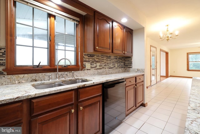 kitchen with light stone counters, a sink, decorative backsplash, dishwasher, and a notable chandelier