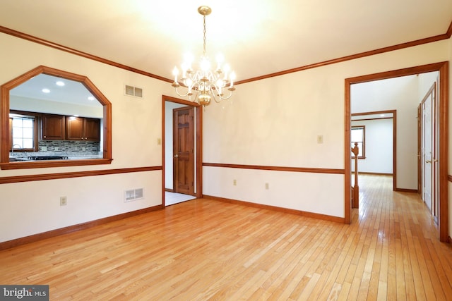 empty room with visible vents, baseboards, light wood-type flooring, and an inviting chandelier