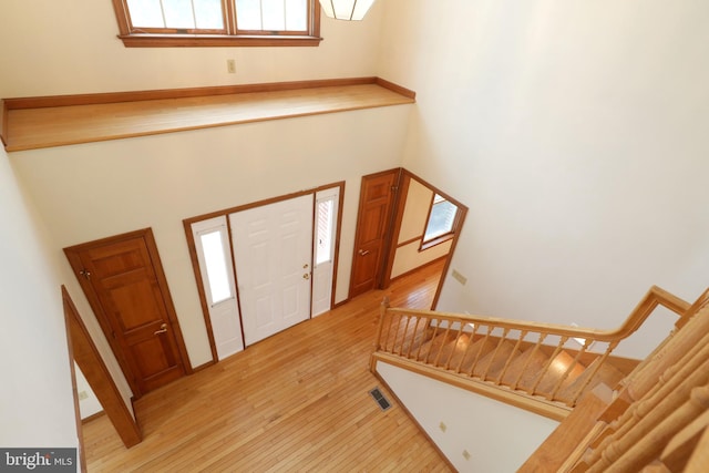 entrance foyer with visible vents, light wood-style flooring, and stairs