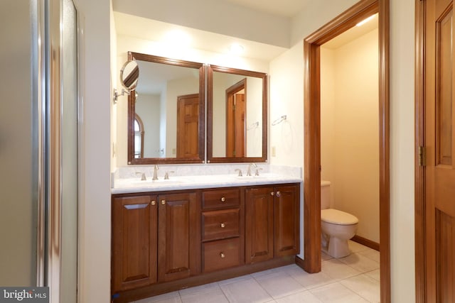 full bath featuring tile patterned flooring, double vanity, toilet, and a sink