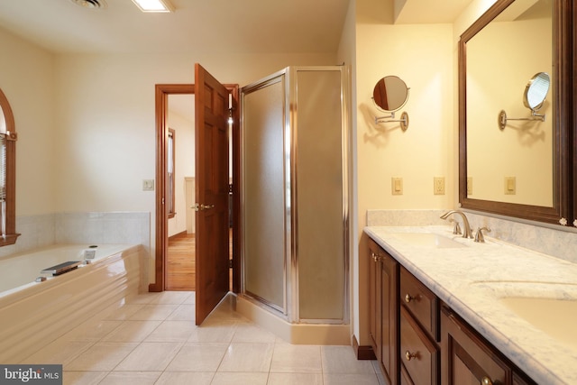 bathroom with tile patterned flooring, a stall shower, double vanity, and a sink