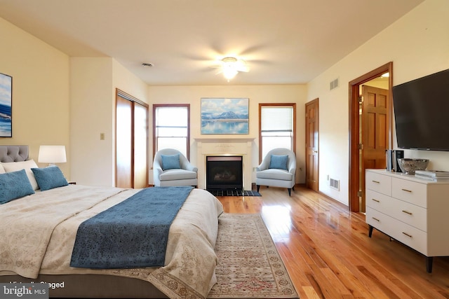 bedroom with visible vents, multiple windows, and light wood-style flooring