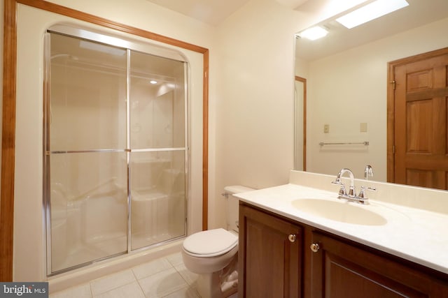 bathroom with vanity, a shower stall, toilet, and tile patterned floors