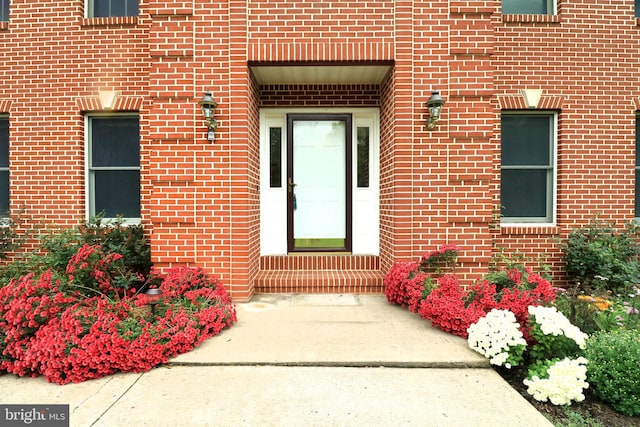 entrance to property featuring brick siding
