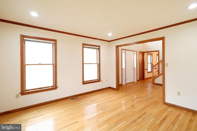 spare room featuring visible vents, baseboards, recessed lighting, ornamental molding, and light wood-style floors