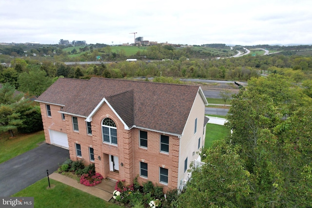 view of front of house featuring aphalt driveway, a garage, brick siding, and a shingled roof