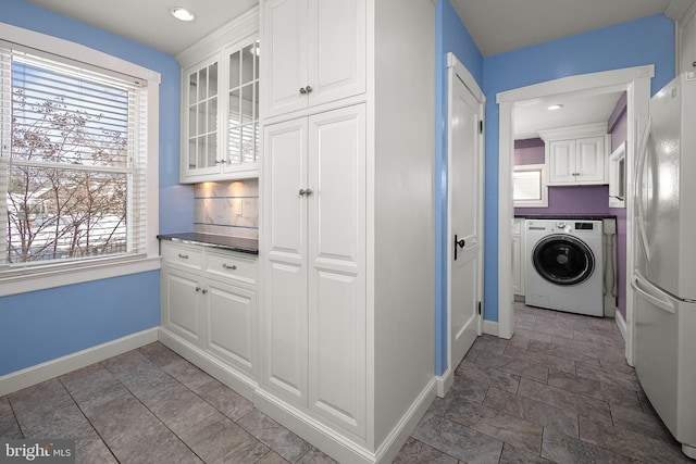 laundry room with a wealth of natural light, cabinets, and washer / dryer