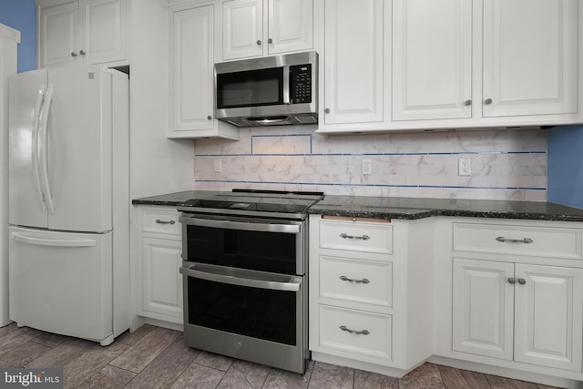 kitchen featuring white cabinets, dark stone countertops, and stainless steel appliances