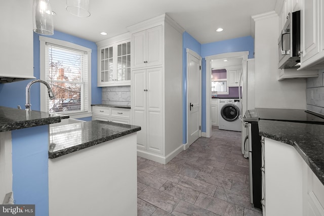 kitchen with white cabinets, decorative light fixtures, range with electric cooktop, and washer / clothes dryer