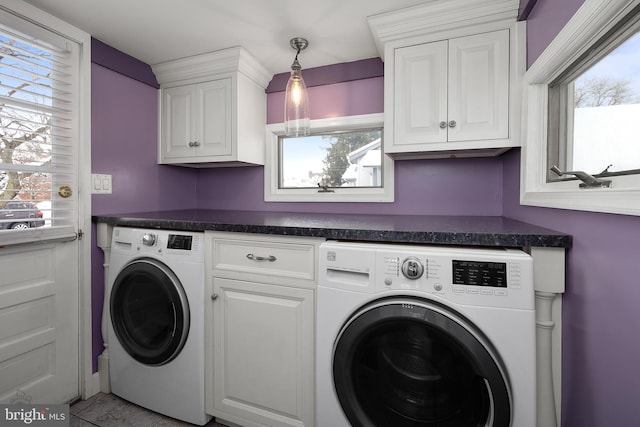 laundry room featuring cabinets, light tile patterned floors, plenty of natural light, and washer and dryer