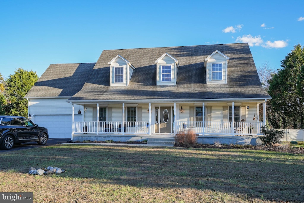 cape cod-style house featuring a porch, a front yard, and a garage