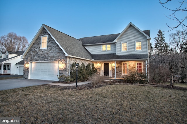 traditional-style house with a shingled roof, a garage, stone siding, driveway, and a front lawn