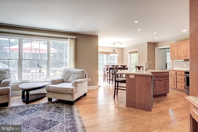 kitchen with light wood-type flooring, light brown cabinets, light countertops, and a kitchen breakfast bar