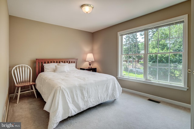 carpeted bedroom featuring visible vents and baseboards