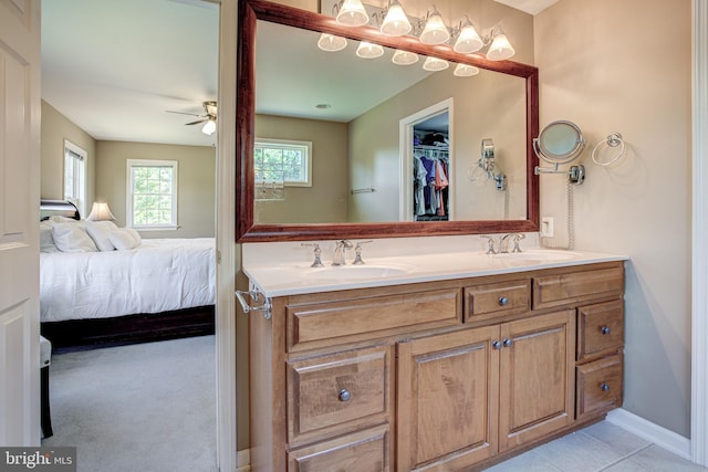 full bath with double vanity, ensuite bath, a ceiling fan, and a sink