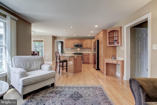 interior space featuring a breakfast bar area, appliances with stainless steel finishes, open floor plan, and light countertops