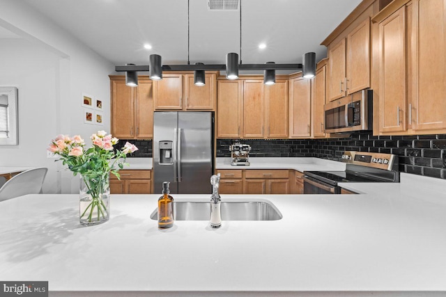 kitchen with kitchen peninsula, decorative backsplash, sink, and stainless steel appliances