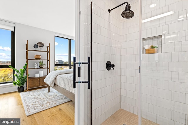 bathroom featuring wood-type flooring and an enclosed shower