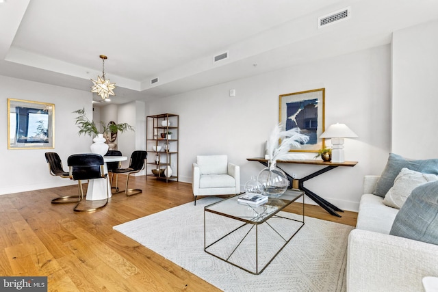 living room featuring wood-type flooring and a tray ceiling