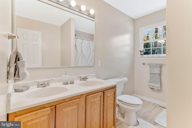 bathroom with vanity, wood-type flooring, and toilet