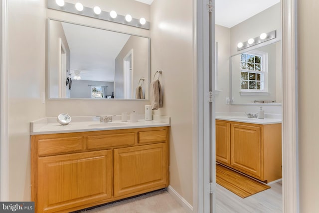 bathroom with hardwood / wood-style floors, vanity, and ceiling fan