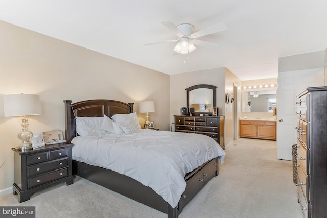 bedroom featuring connected bathroom, light colored carpet, and ceiling fan