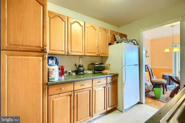 kitchen featuring pendant lighting, white fridge, and a chandelier