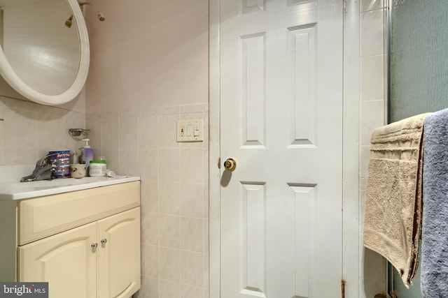 bathroom featuring vanity and tile walls