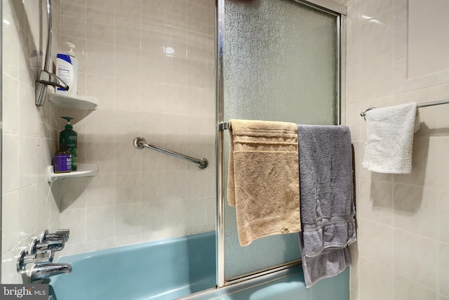 bathroom with bath / shower combo with glass door