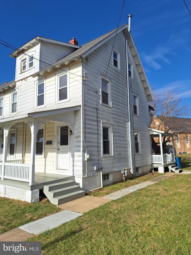 view of front of house with covered porch and a front lawn