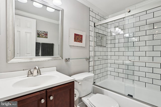 full bathroom with vanity, bath / shower combo with glass door, ornamental molding, and toilet