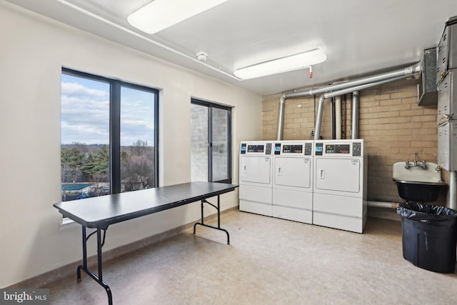 clothes washing area featuring separate washer and dryer and sink