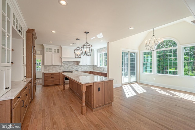 kitchen with light hardwood / wood-style floors, white cabinetry, a wealth of natural light, and a large island