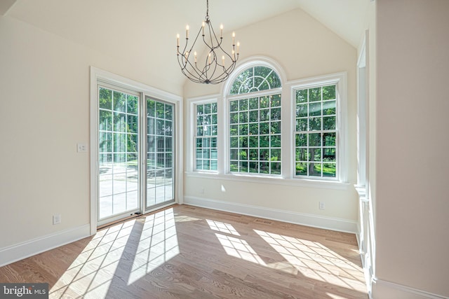 unfurnished dining area featuring light hardwood / wood-style floors, lofted ceiling, and a wealth of natural light