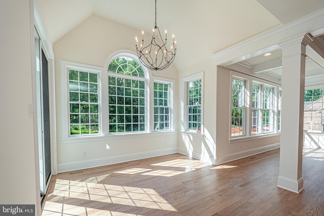 unfurnished sunroom featuring a chandelier, plenty of natural light, and lofted ceiling