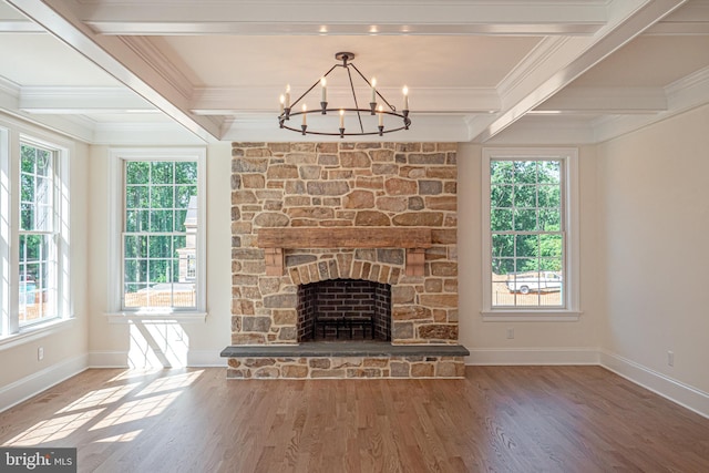 unfurnished living room featuring wood-type flooring, a stone fireplace, and a healthy amount of sunlight