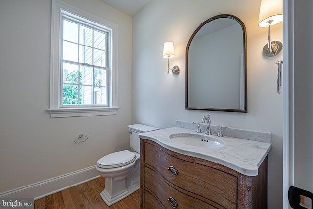 bathroom with toilet, vanity, and hardwood / wood-style flooring