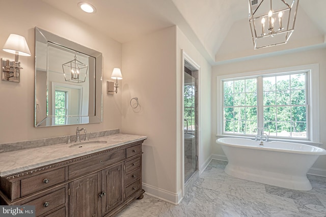 bathroom featuring vanity, vaulted ceiling, and a tub