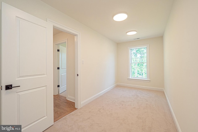 unfurnished room featuring light carpet