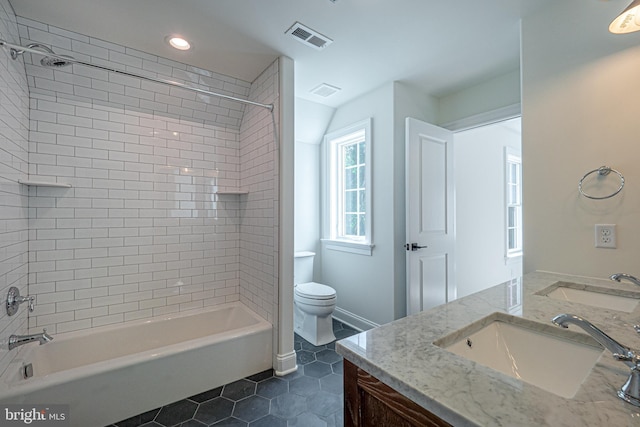 full bathroom with tile patterned flooring, vanity, toilet, and tiled shower / bath combo