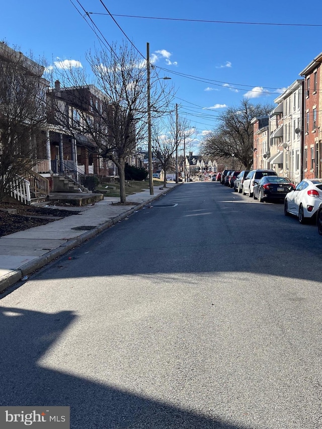 view of street with a residential view, curbs, and sidewalks