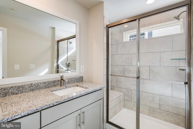 bathroom featuring vanity and a shower with shower door